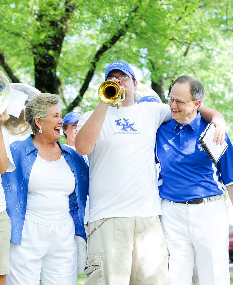 Lee and Patsy Todd at a pep rally with a student playing a trumpet